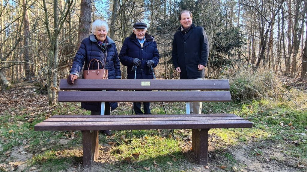 Frau Dr. Kaltenbach, Herr Prof. Dr. Kaltenbach und Erster Stadtrat Martin Burlon stehen hinter der gespendeten Bank.