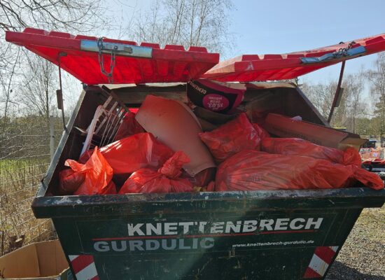 Ein Container voll mit roten Müllsäckern von der Frühjahrsputzaktion